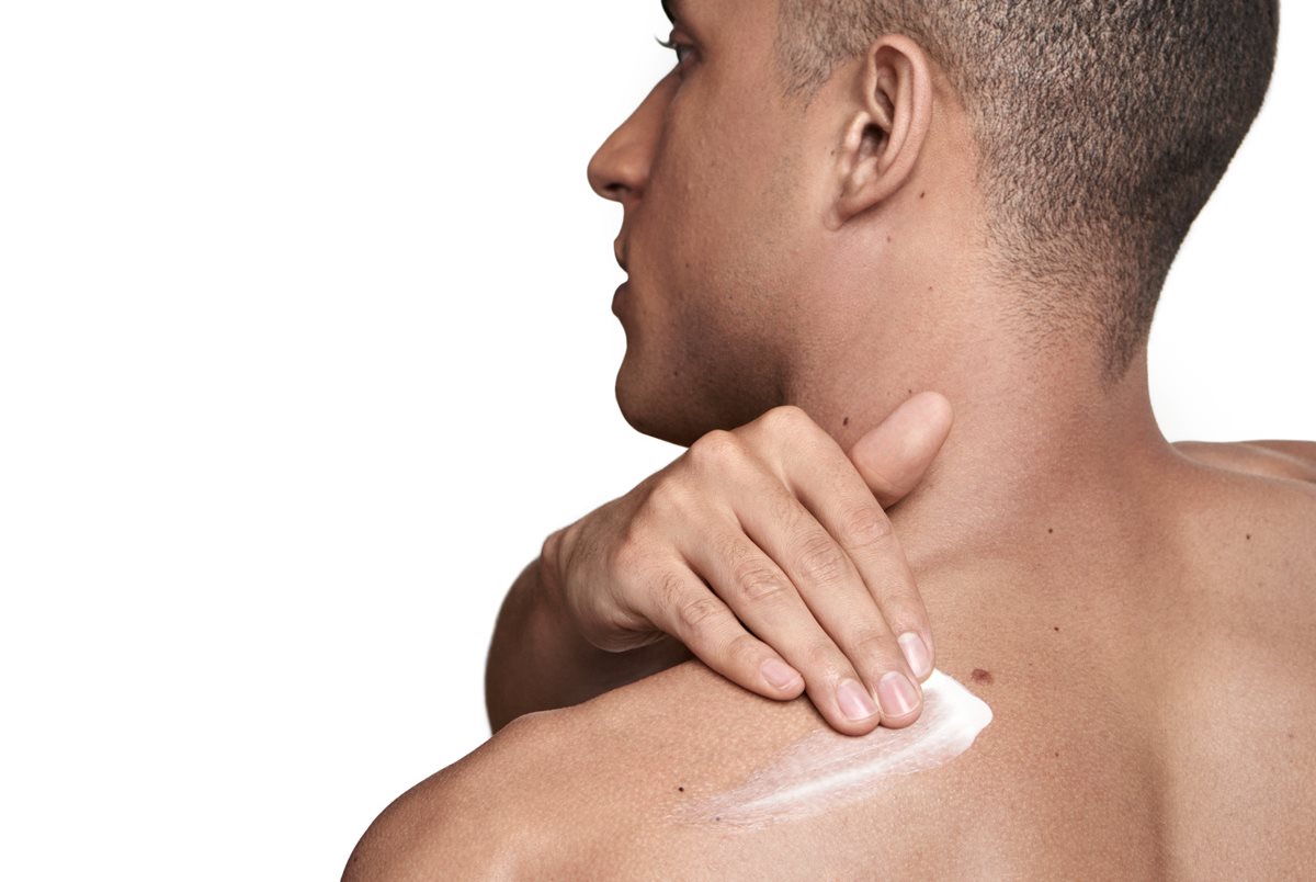 man applying cream to back acne